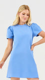 Woman wearing a light blue dress against a white background