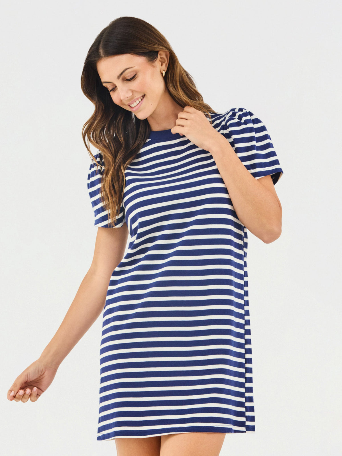 Woman wearing a blue and white striped dress on a plain background