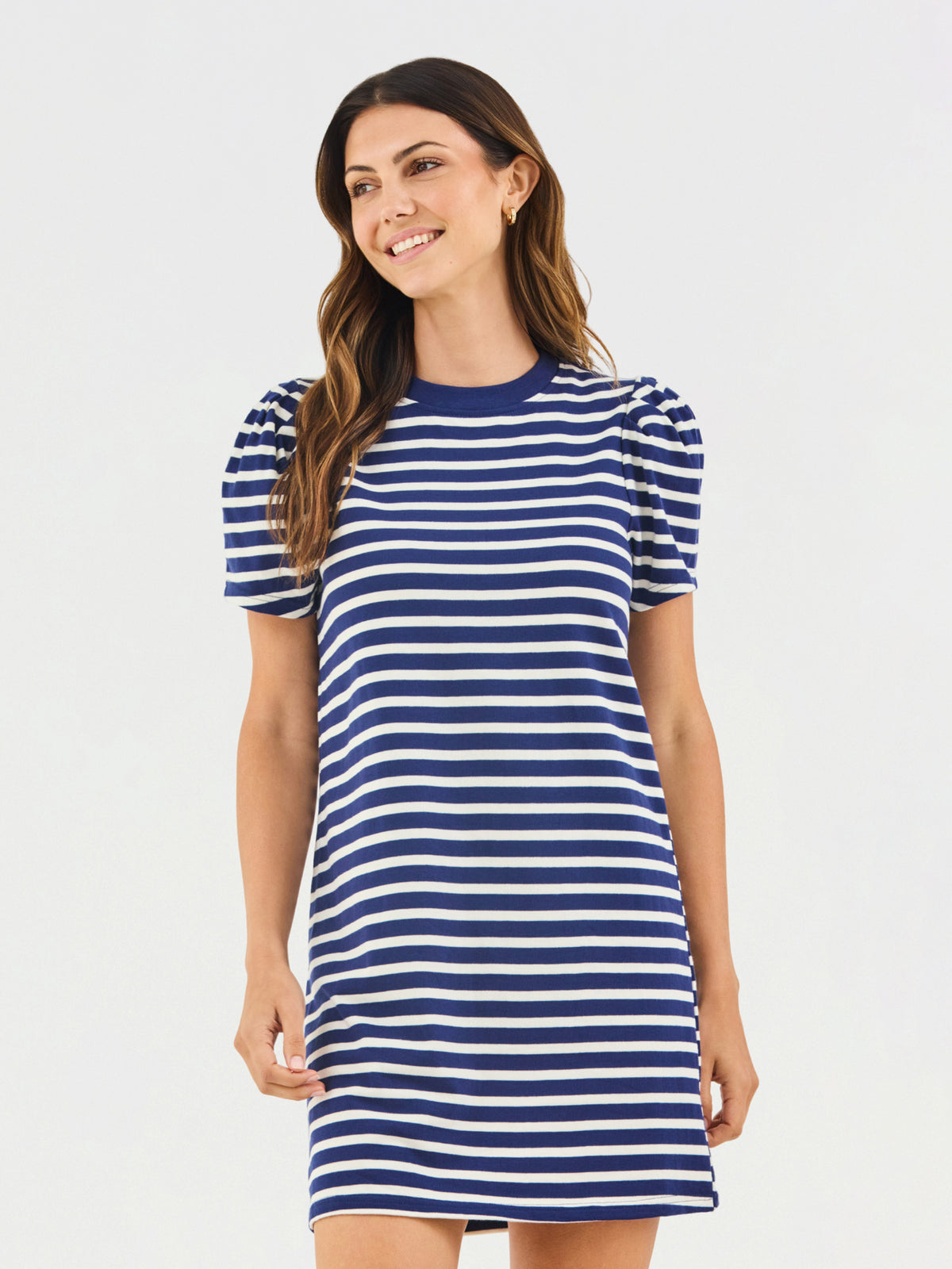 Woman wearing a blue and white striped dress on a light gray background