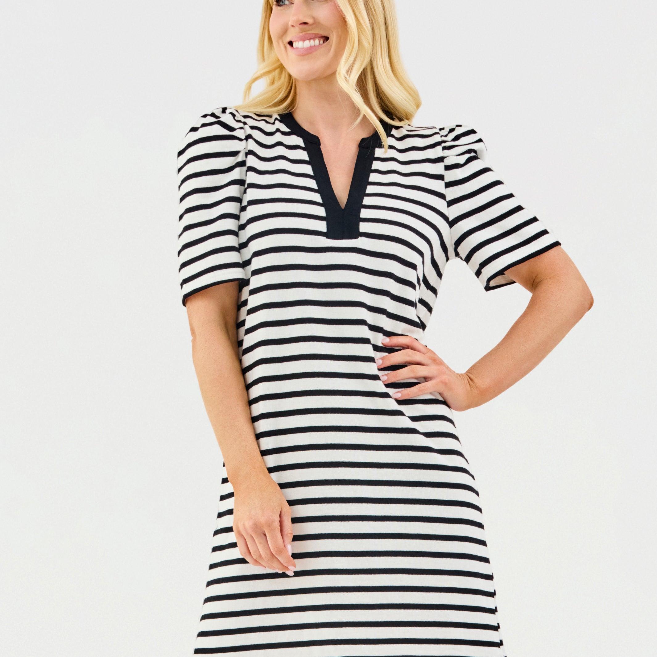 Woman wearing a black and white striped dress on a light gray background