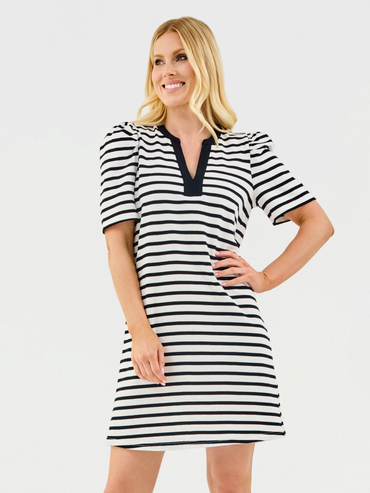 Woman wearing a black and white striped dress on a light gray background
