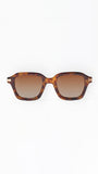 Sunglasses with tortoiseshell frame and brown lenses on a white background