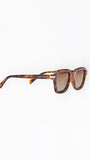 Sunglasses with tortoiseshell frame and brown lenses on a white background