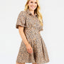 A woman modeling a short-sleeve collared dress with a beige, brown, and black leopard print pattern, set against a plain white studio background.