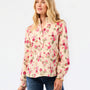 A woman modeling a long-sleeve floral blouse with a stand collar, paired with blue jeans, against a plain white studio background.