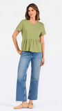 A woman wearing a sage green short-sleeve top with a gathered peplum hem, paired with blue jeans, against a plain white background.
