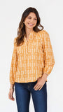 A woman modeling a long-sleeve yellow blouse with a white vertical pattern, paired with dark blue jeans, against a plain white background.