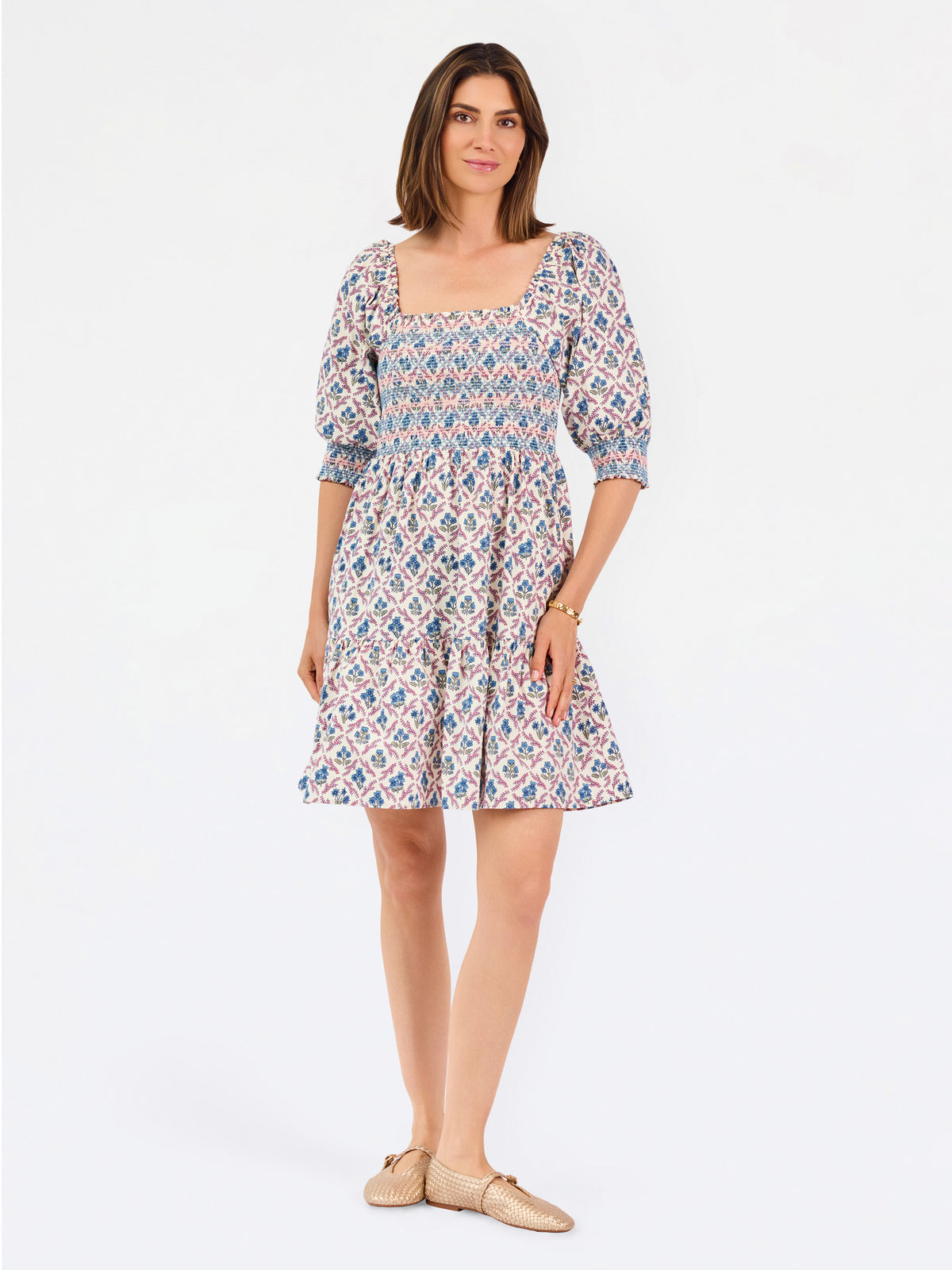Women with short brown hair wearing a mini dress with puff sleeve lattice printed dress with pink and blue floral 