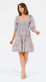 Women with short brown hair wearing a mini dress with puff sleeve lattice printed dress with pink and blue floral 