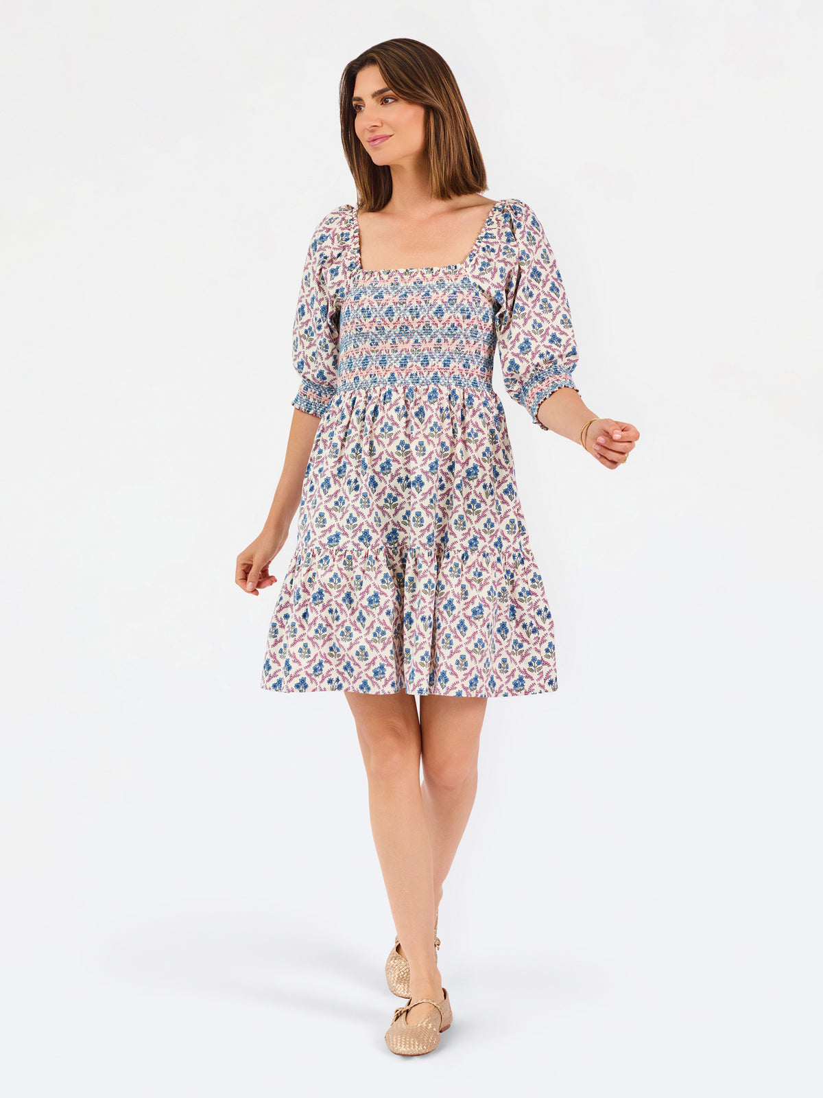 Women with short brown hair wearing a mini dress with puff sleeve lattice printed dress with pink and blue floral 
