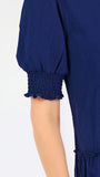 Women with short brown hair wearing a navy blue mini dress with puff sleeves and seersucker 