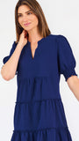 Women with short brown hair wearing a navy blue mini dress with puff sleeves and seersucker 