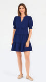 Women with short brown hair wearing a navy blue mini dress with puff sleeves and seersucker 