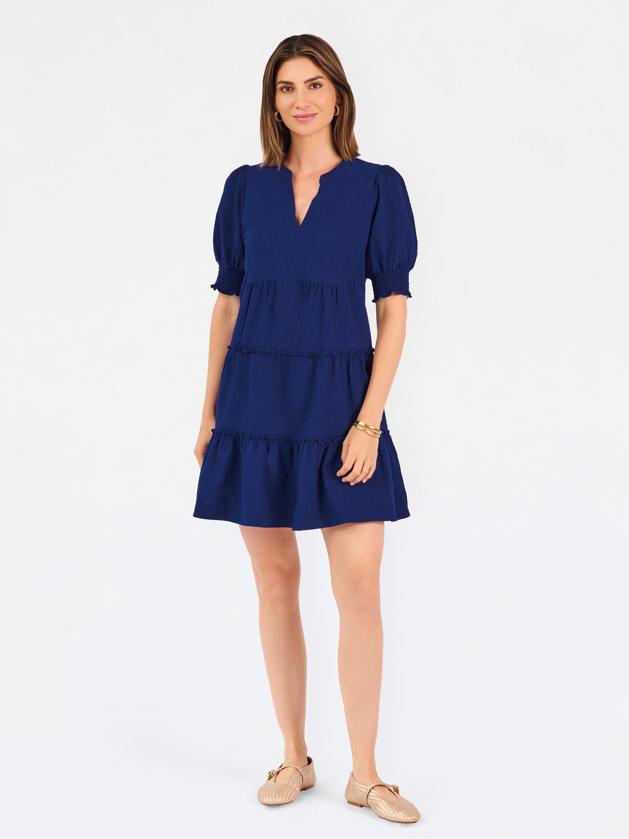 Women with short brown hair wearing a navy blue mini dress with puff sleeves and seersucker 