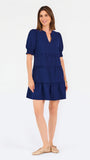 Women with short brown hair wearing a navy blue mini dress with puff sleeves and seersucker 