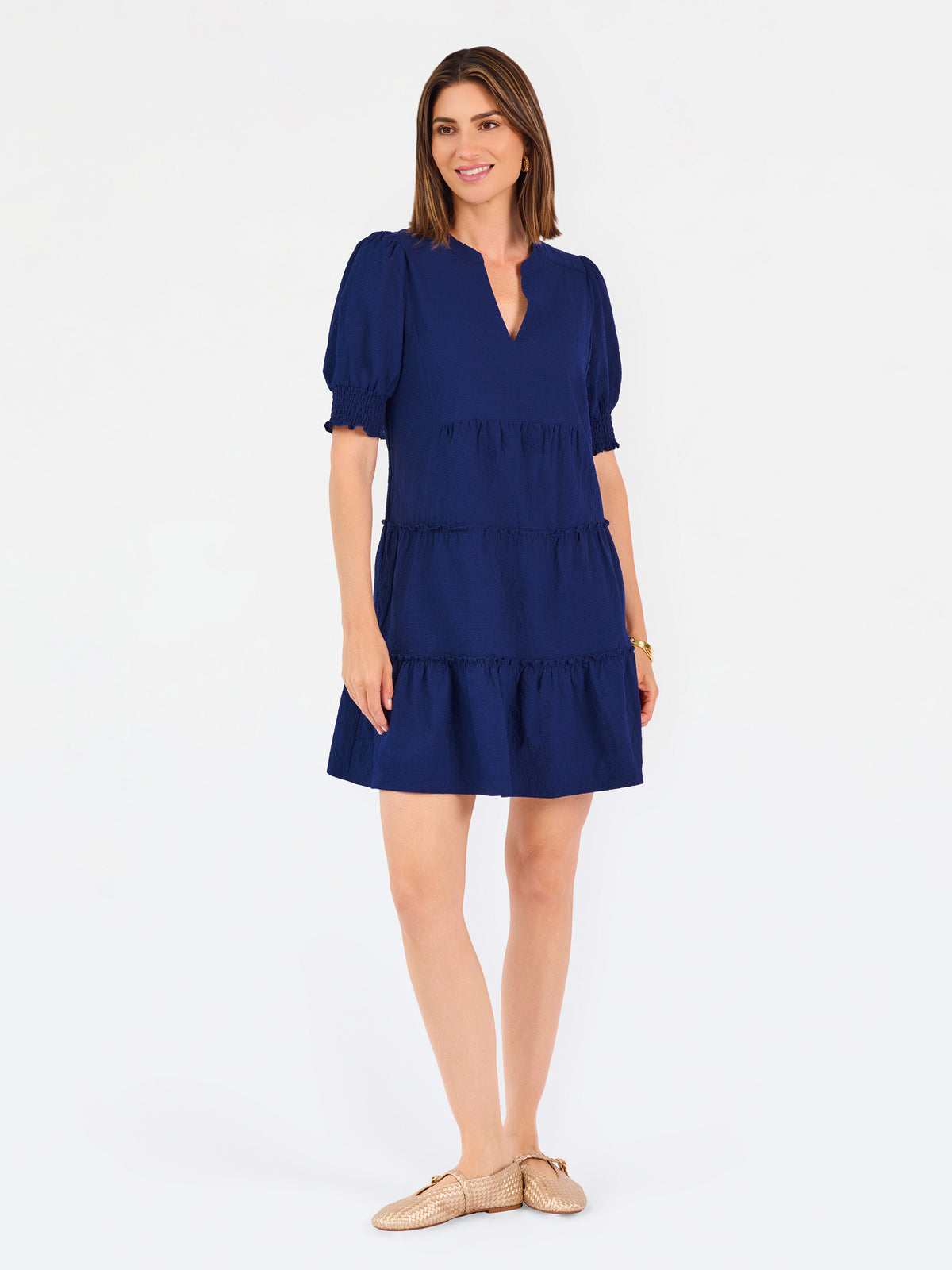 Women with short brown hair wearing a navy blue mini dress with puff sleeves and seersucker 