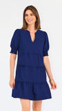 Women with short brown hair wearing a navy blue mini dress with puff sleeves and seersucker 