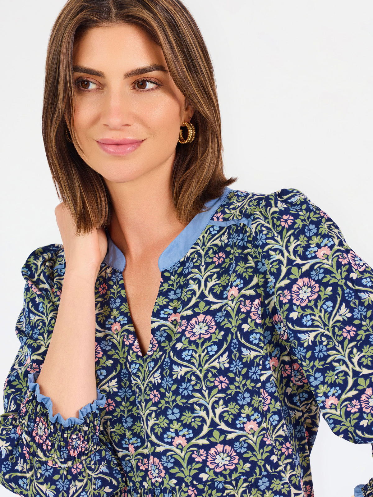 Women with short brown hair wearing a blue printed mini dress with three quarter puff sleeves and blue trim 