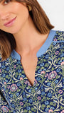 Women with short brown hair wearing a blue printed mini dress with three quarter puff sleeves and blue trim 