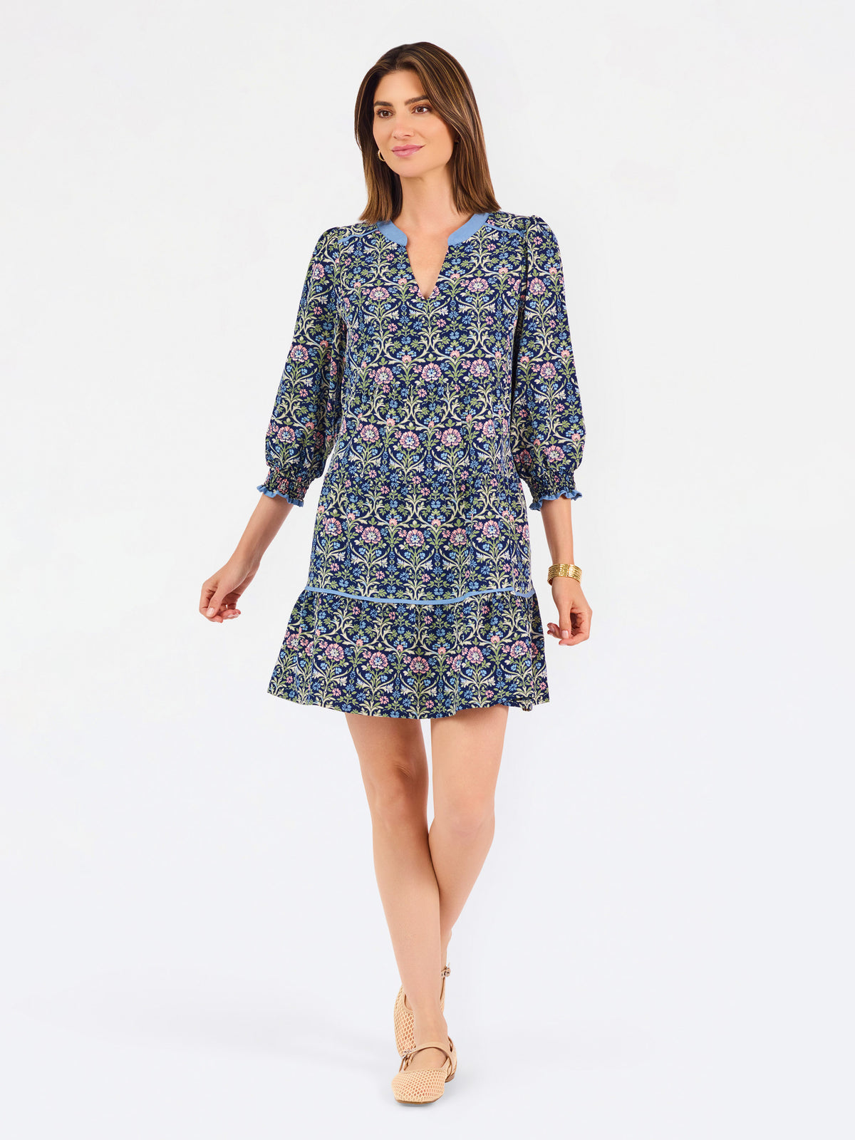 Women with short brown hair wearing a blue printed mini dress with three quarter puff sleeves and blue trim 