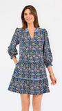 Women with short brown hair wearing a blue printed mini dress with three quarter puff sleeves and blue trim 