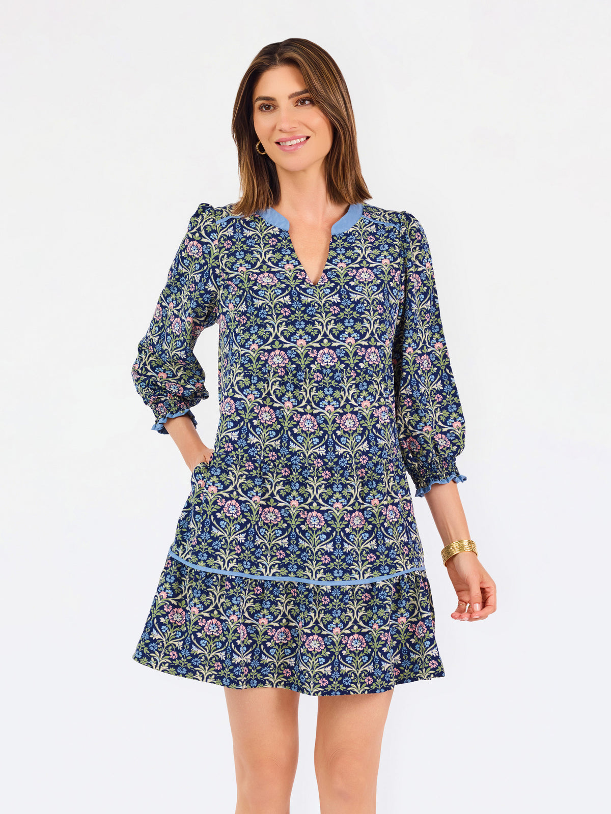 Women with short brown hair wearing a blue printed mini dress with three quarter puff sleeves and blue trim 