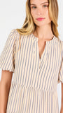 A woman modeling a short-sleeve midi dress with vertical beige and white stripes, featuring a tiered ruffle hem and a split neckline, set against a plain white studio background.