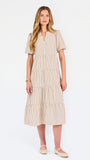 A woman modeling a short-sleeve midi dress with vertical beige and white stripes, featuring a tiered ruffle hem and a split neckline, set against a plain white studio background.