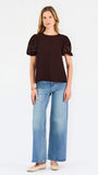 Blonde woman wearing a short sleeve brown colored top with cut out detail on puff sleeves