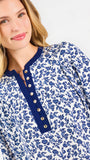Blonde woman wearing a long sleeve blue floral navy top with blue neckline 
