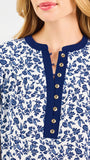 Blonde woman wearing a long sleeve blue floral navy top with blue neckline 