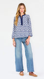 Blonde woman wearing a long sleeve blue floral navy top with blue neckline 