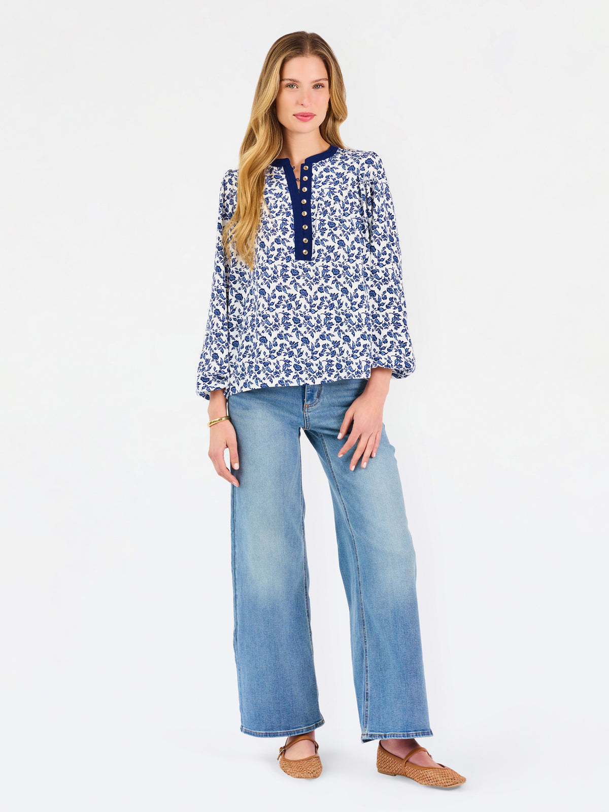 Blonde woman wearing a long sleeve blue floral navy top with blue neckline 