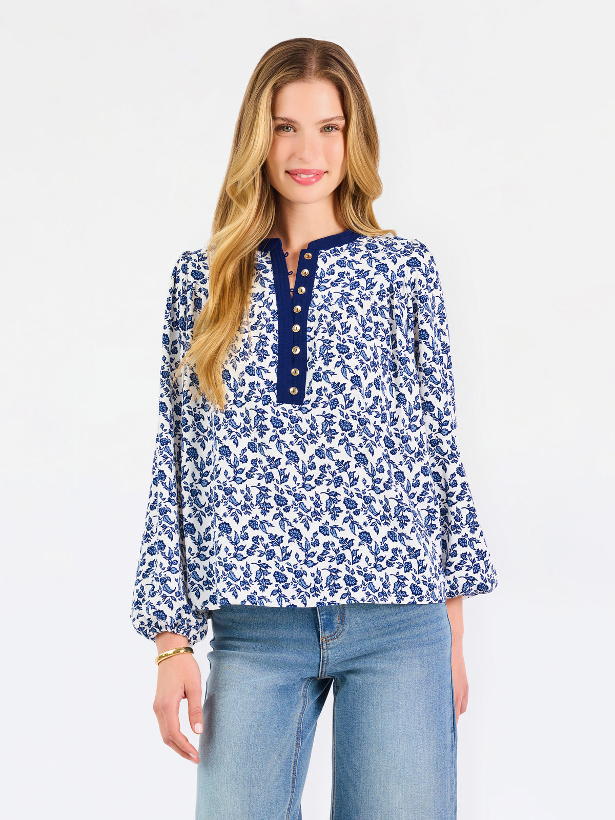 Blonde woman wearing a long sleeve blue floral navy top with blue neckline 
