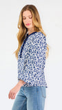 Blonde woman wearing a long sleeve blue floral navy top with blue neckline 