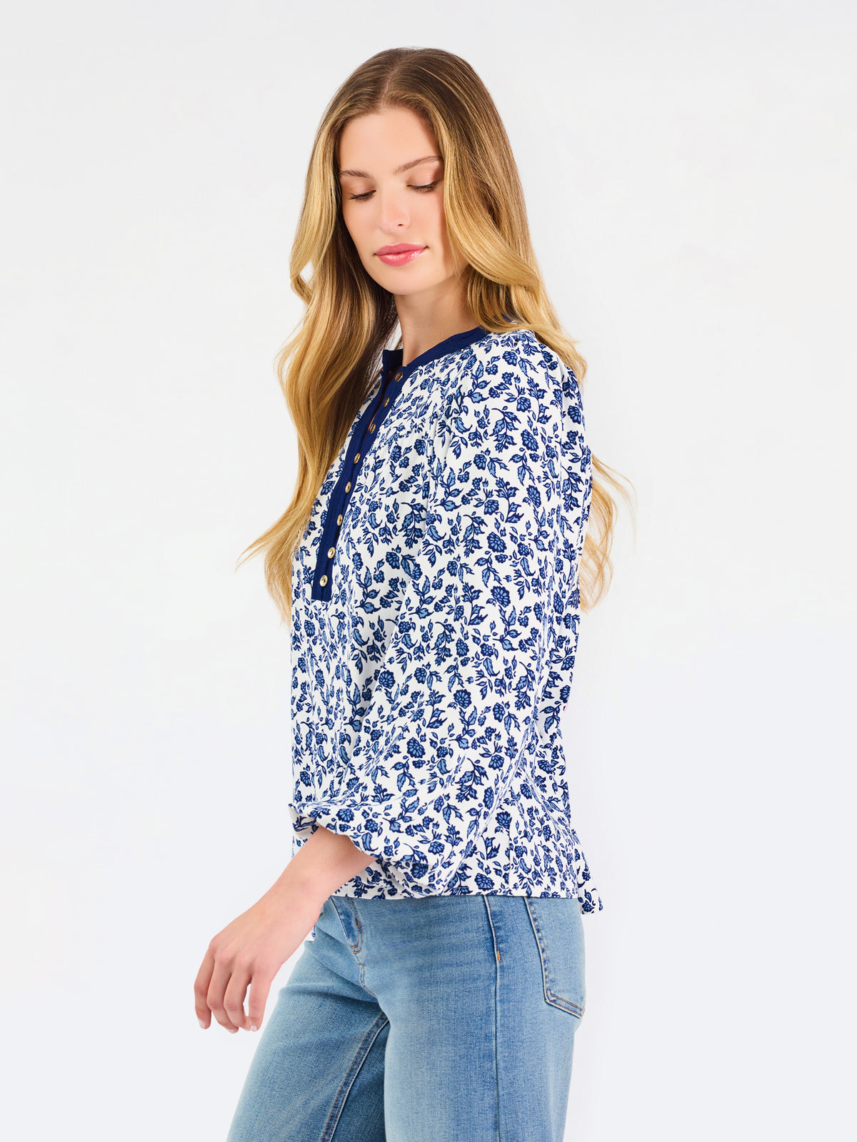 Blonde woman wearing a long sleeve blue floral navy top with blue neckline 