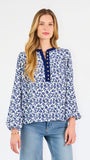 Blonde woman wearing a long sleeve blue floral navy top with blue neckline 