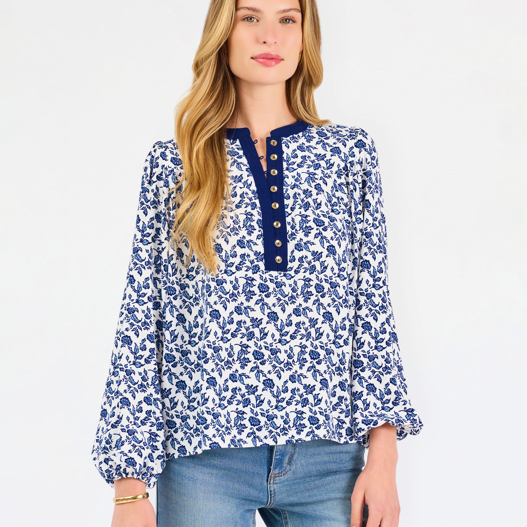 Blonde woman wearing a long sleeve blue floral navy top with blue neckline 