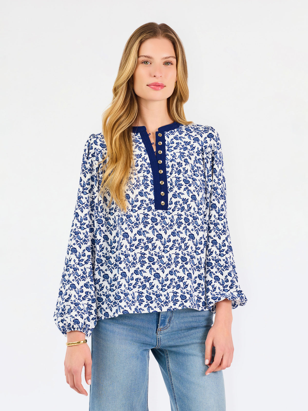 Blonde woman wearing a long sleeve blue floral navy top with blue neckline 