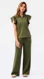 A woman modeling a matching olive green two-piece set consisting of a ruffled short-sleeve quarter-zip top and wide-leg pants, photographed against a clean white studio 