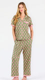 Woman wearing a green and pink floral pajama set on a white background