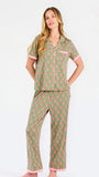 Woman wearing a green and pink floral pajama set on a white background