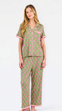 Woman wearing a green and pink floral pajama set on a white background