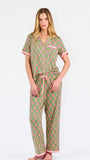 Woman wearing a green and pink floral pajama set on a white background