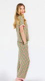 Woman wearing a green and pink floral pajama set on a white background