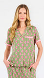 Woman wearing a green and pink floral pajama set on a white background
