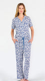 Blonde woman wearing a blue floral pajama set on a white background