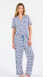Blonde woman wearing a blue floral pajama set on a white background