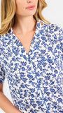 Blonde woman wearing a blue floral pajama set on a white background