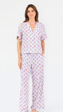 Woman wearing a purple floral pajama set on a white background